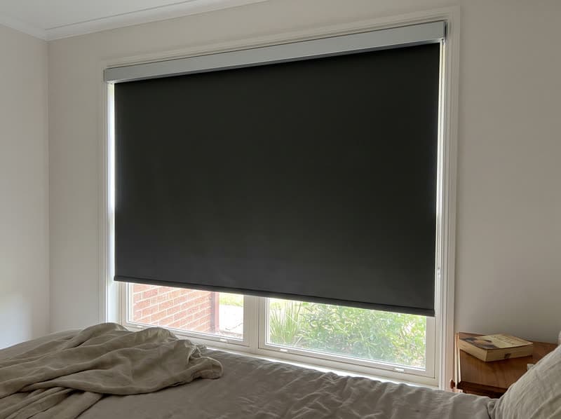 Blackout roller shade fully lowered on a bedroom window in an Alpharetta brick colonial home