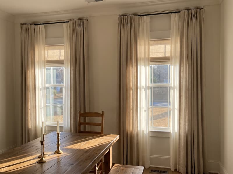 Ivory sheer drapery panels over a linen roman shade in a Kennesaw dining room